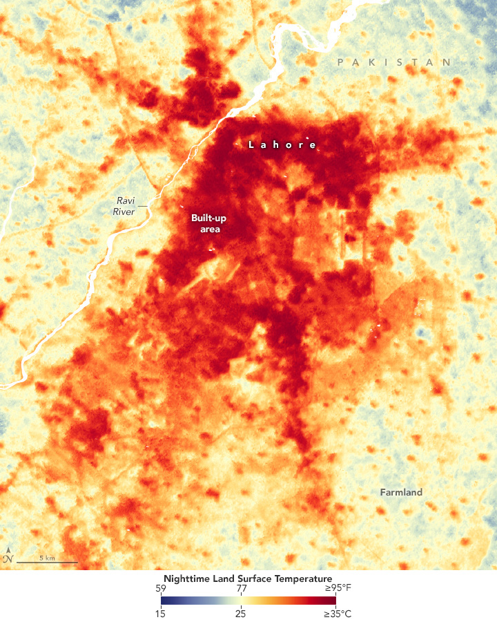 A satellite image heat map of a city in Pakistan where the color range is from blue to yellow to red, the darkest of the colors reflect the temperatures 15C and 35C respectively. The edges of the images show a smattering of blue shades breaking through, but the center of the image where the city is shows up almost universally red or orange, and only a few patches of neutral breaking through.