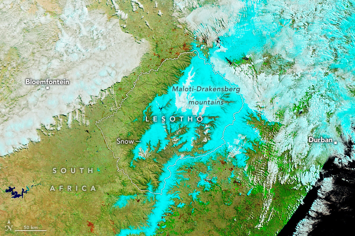 Lesotho appears to be largely overlayed with vibrant blue color, indicative of snow. The snow extends into South Africa as well, though less dense than shown in Lesotho. The ocean appears in the lower right corner, appearing nearly black, and the city of Durban on the coastline is included in the snow cover. The city of Bloemfontein is marked on the left of the image.