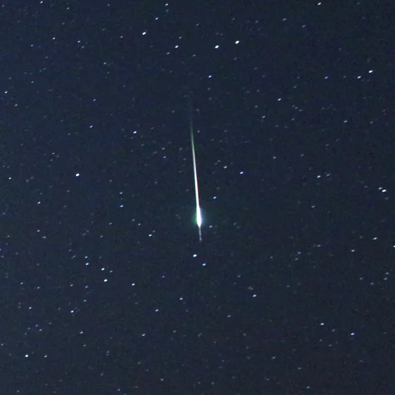 Closeup view of a bright meteor flaring against a dark background sky