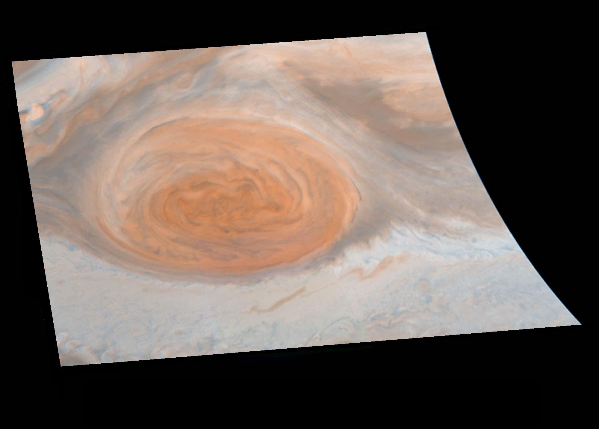 Jupiter's Great Red Spot has a faint orange blush in this close up image of the storm and surrounding swirling clouds.
