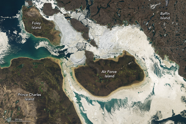 Four islands, all brown land, are pictured. Baffin Island occupies the entire upper right corner, and Prince Charles Island the lower left. Between those two islands are two smaller islands, Foley and Air Force islands, with broken sea ice around both. Ocean is clearly visible in a dark blue in the upper left corner near Foley Island.