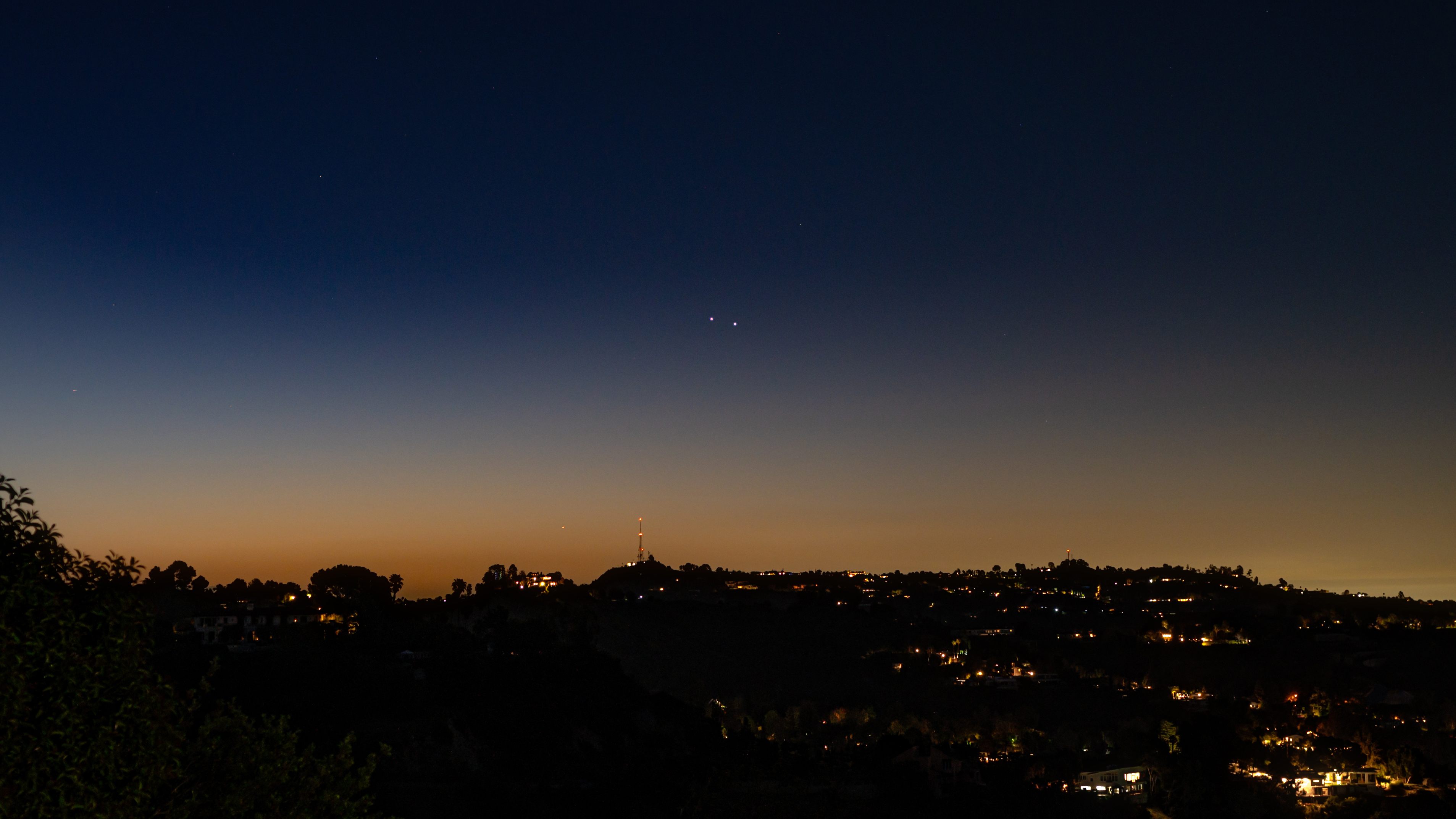 This photo shows the bright dot of Saturn rising over a twilight sky.