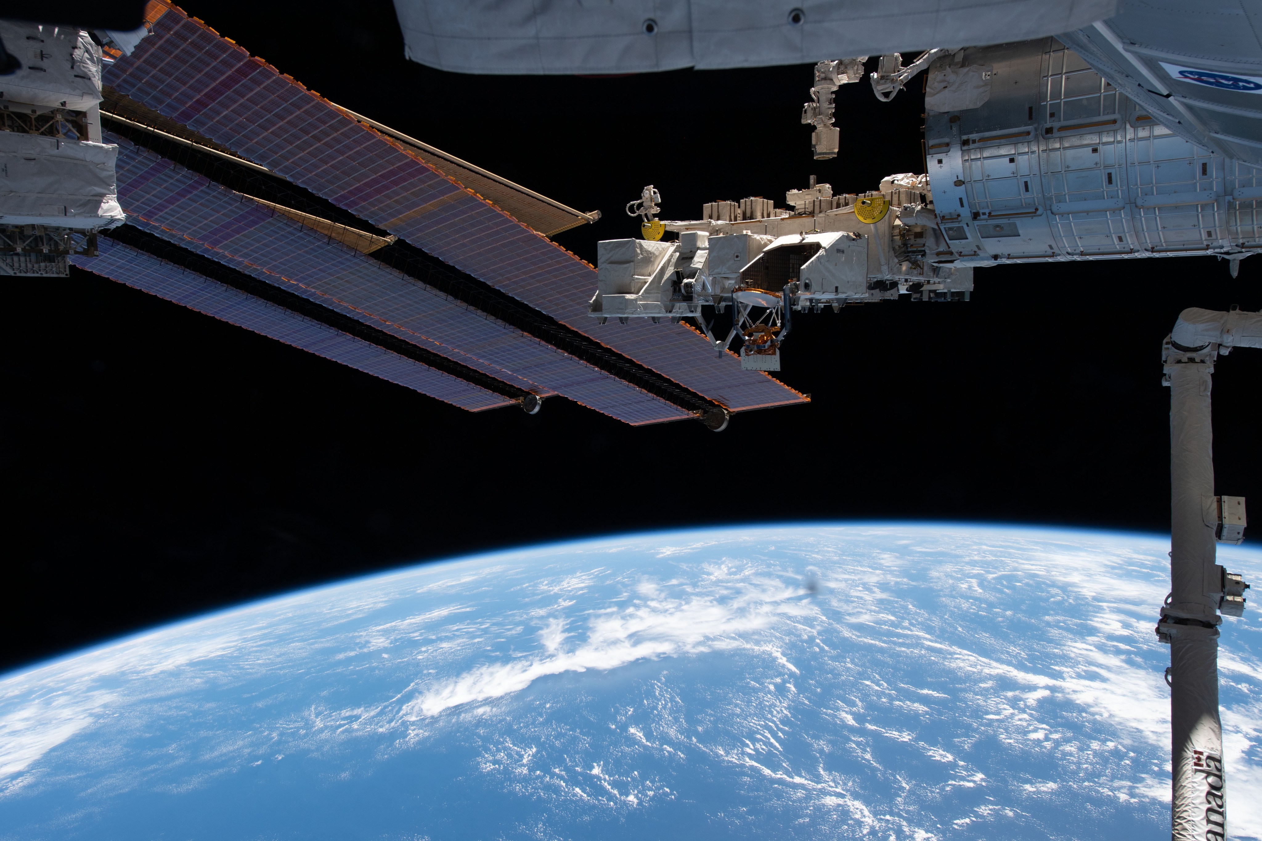 Parts of the International Space Station are visible above the Pacific Ocean in this image taken from ISS.