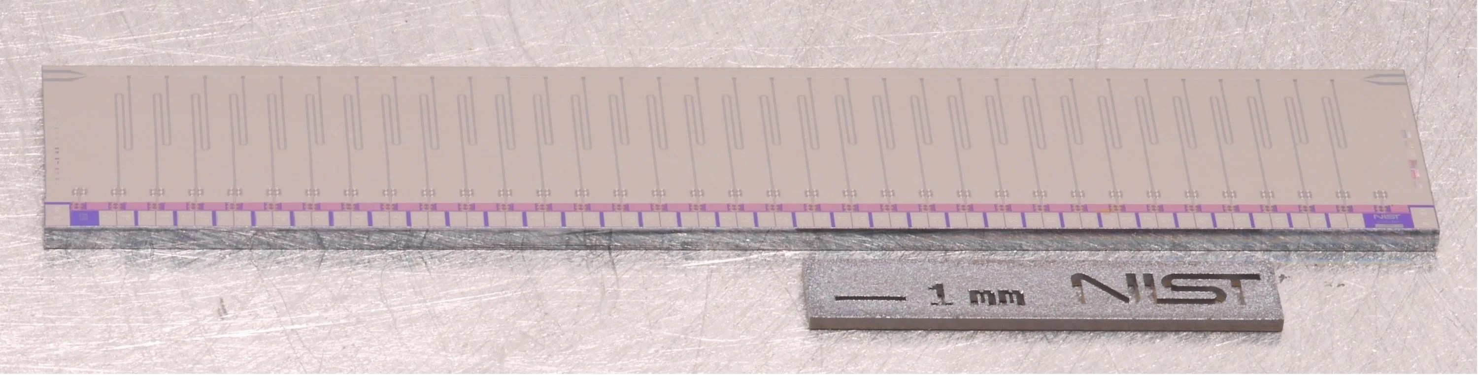 A photograph of a multiplexer chip that is a small, long rectangular object