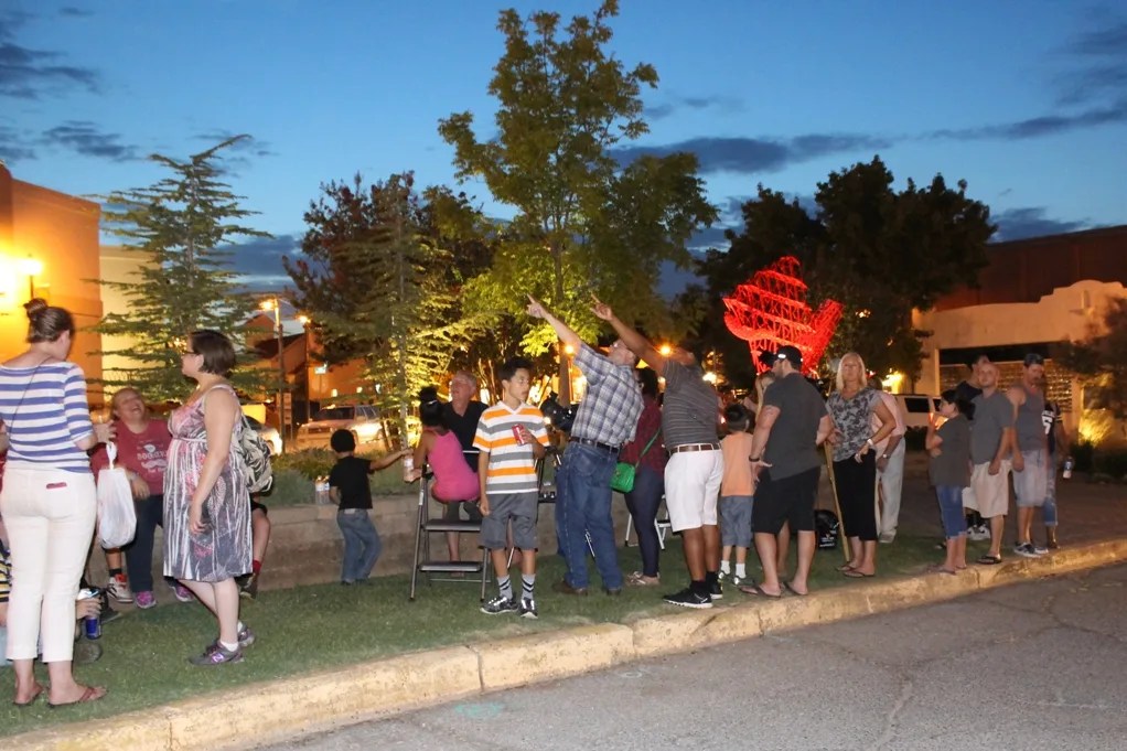 Photograph of people with telescopes looking up at the sky