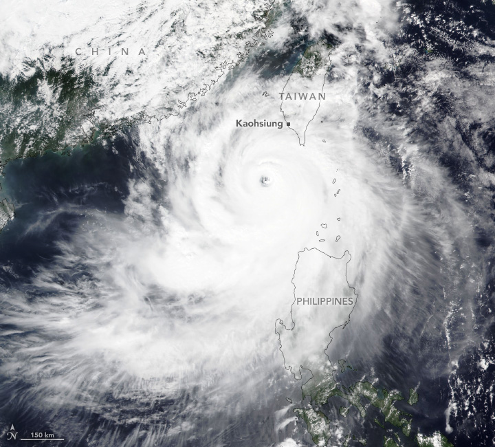 Swirling white clouds center off the coast of China (top left) and Taiwan (near top center). Much of Taiwan has entered the top right corner of the storm and is the nearest landmass to the eye. The Philippines (lower center) are partially covered by the thinner outer edge clouds of the Typhoon.