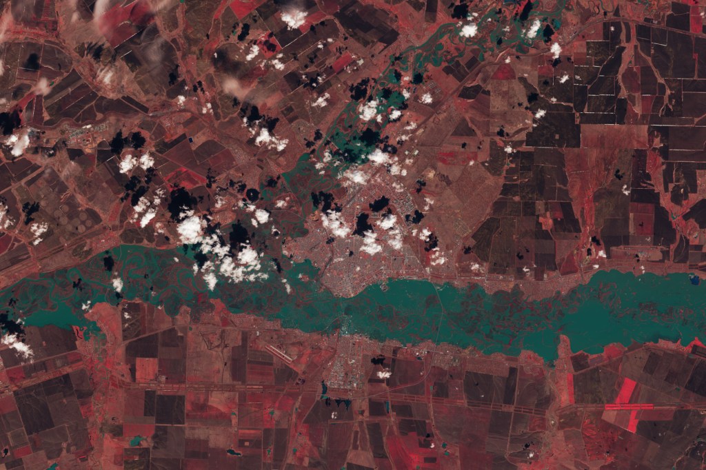 The image is false color (bands 5-4-3) to emphasize the presence of water, which appears blue-green; vegetation appears red. There river in this image fills it's banks and submerged meanders of marsh that exist within them.