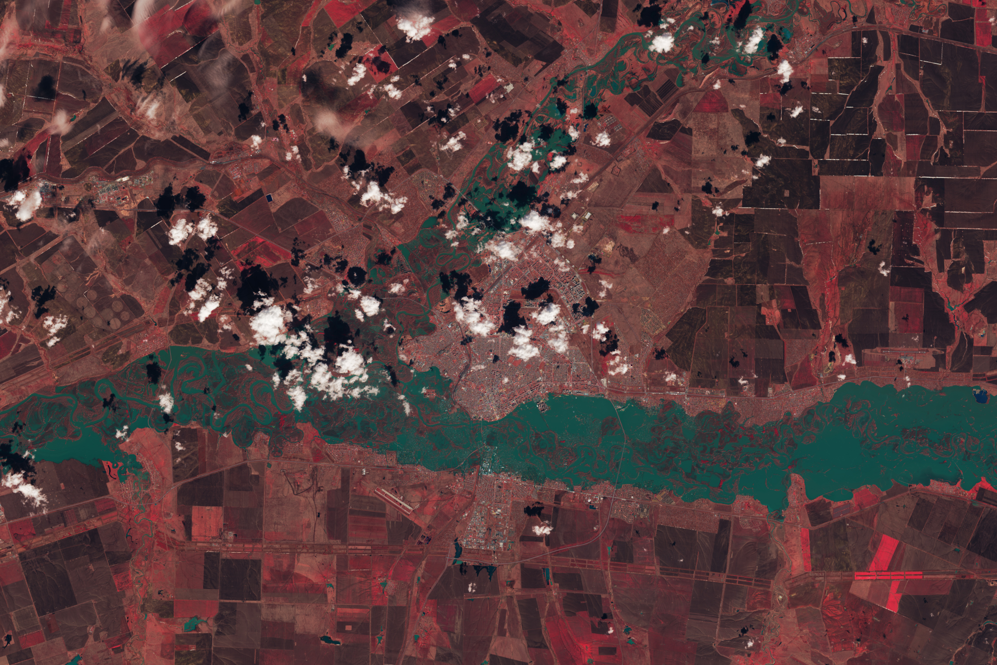 The image is false color (bands 5-4-3) to emphasize the presence of water, which appears blue-green; vegetation appears red. There river in this image fills it's banks and submerged meanders of marsh that exist within them.