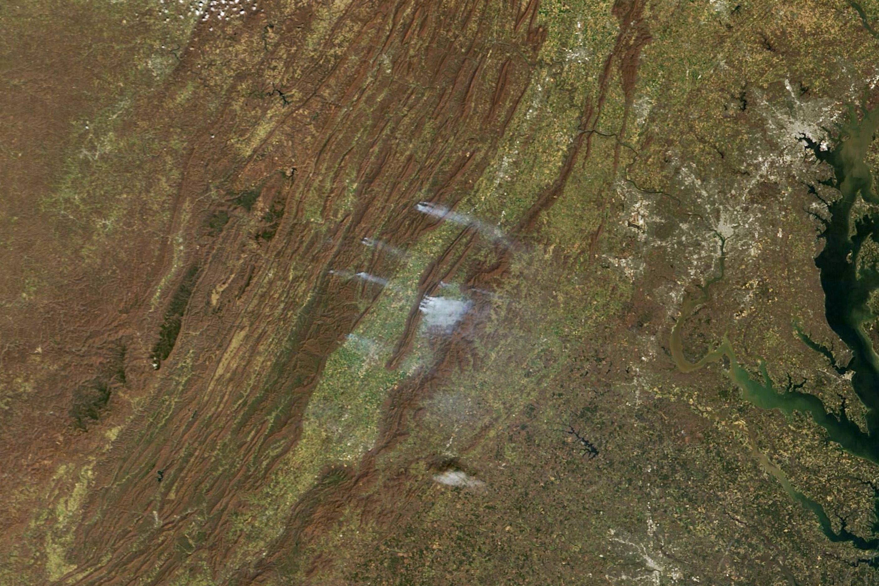 On March 21, the Virginia Department of Forestry said that firefighters had responded to more than 100 wildfires in the previous 48 hours. The fires had burned more than 7,500 acres (3,000 hectares). The MODIS (Moderate Resolution Imaging Spectroradiometer) sensor on NASA’s Terra satellite captured this image of smoke streaming from the fires on that day.