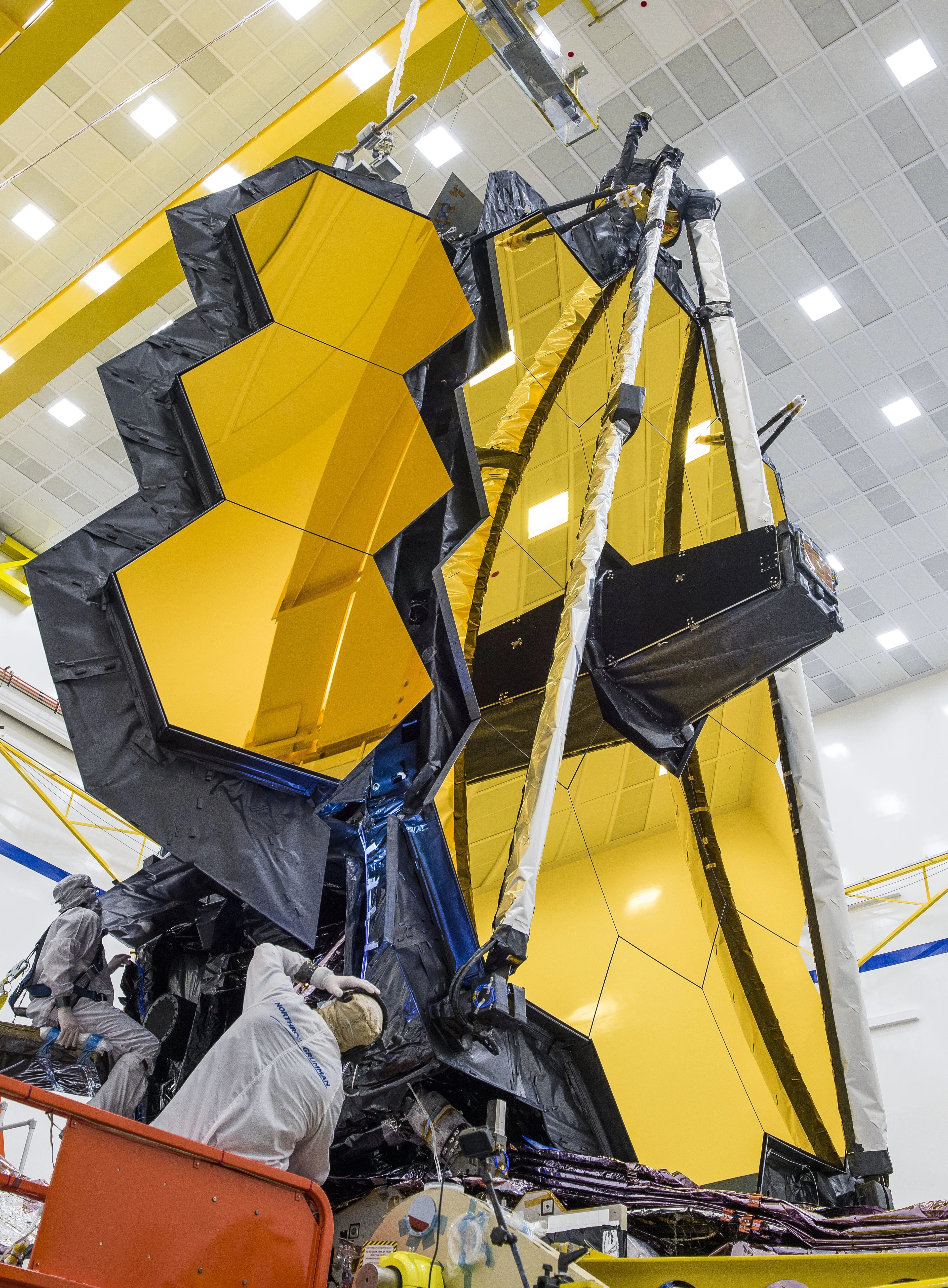 An engineer looks up at the James Webb Space Telescope's Folding MIrrors