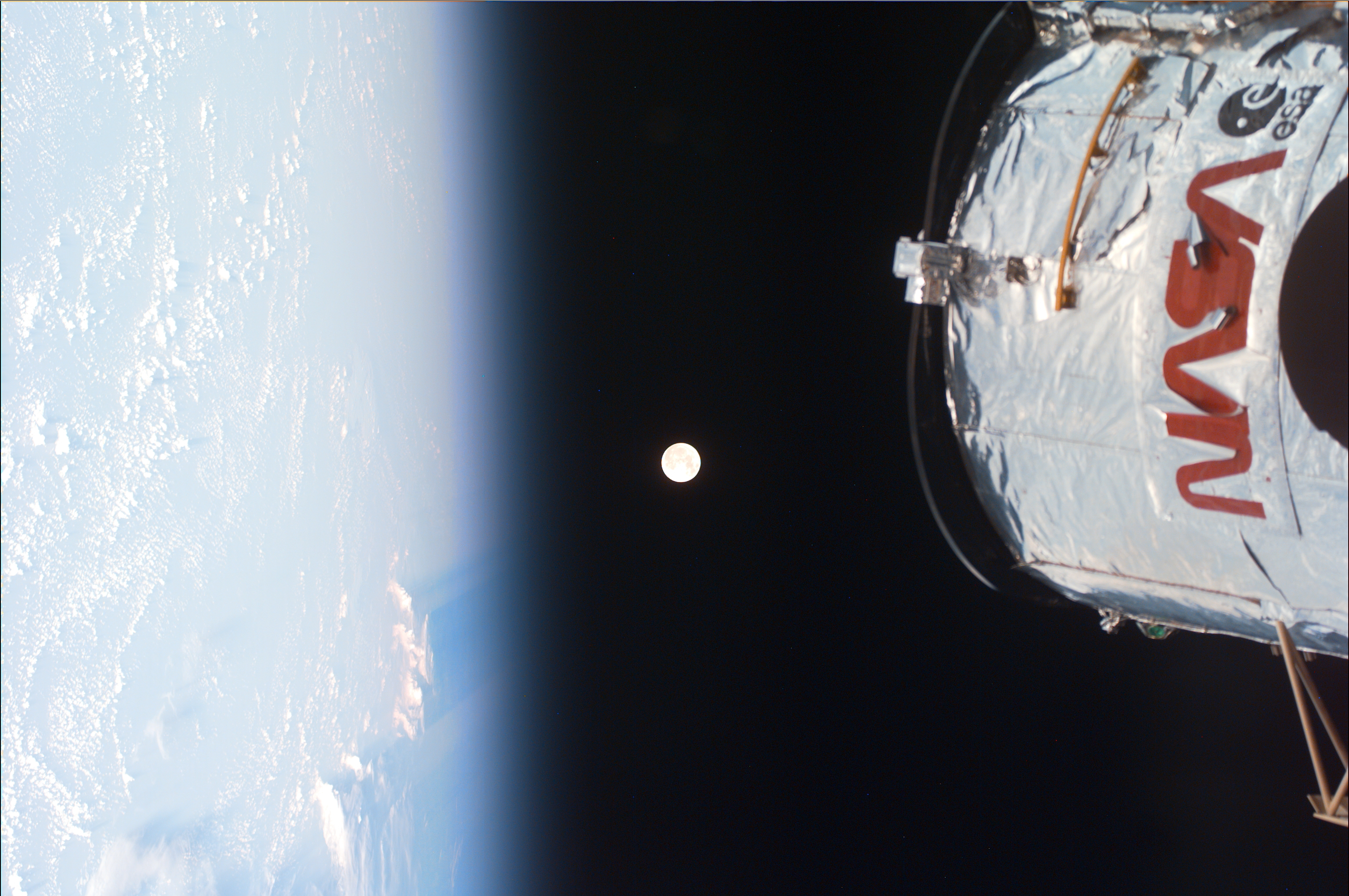 The earth on the left, the moon in the middle, and the top of Hubble on the right.