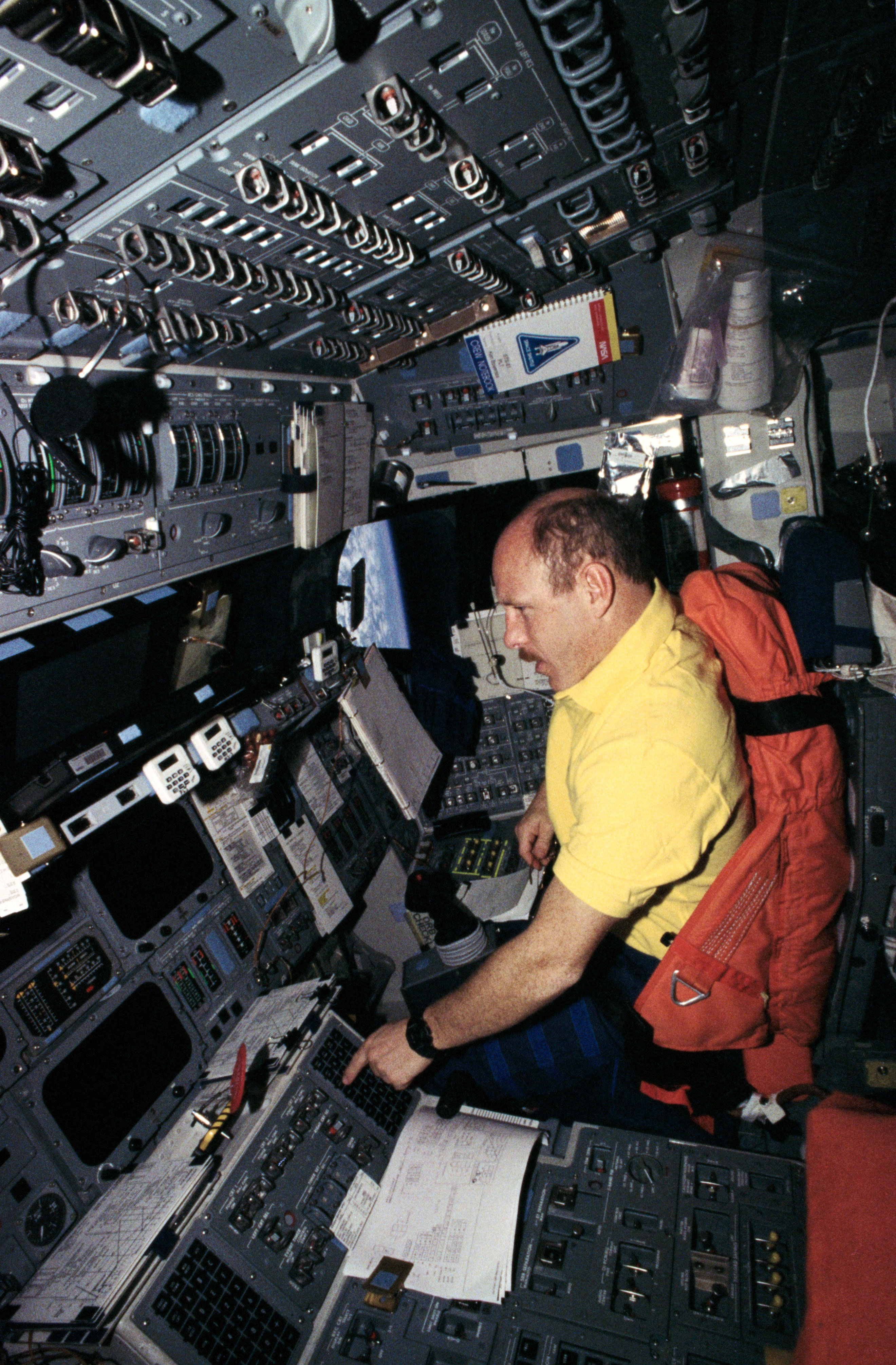 An astronaut at the pilot position in the space shuttle.