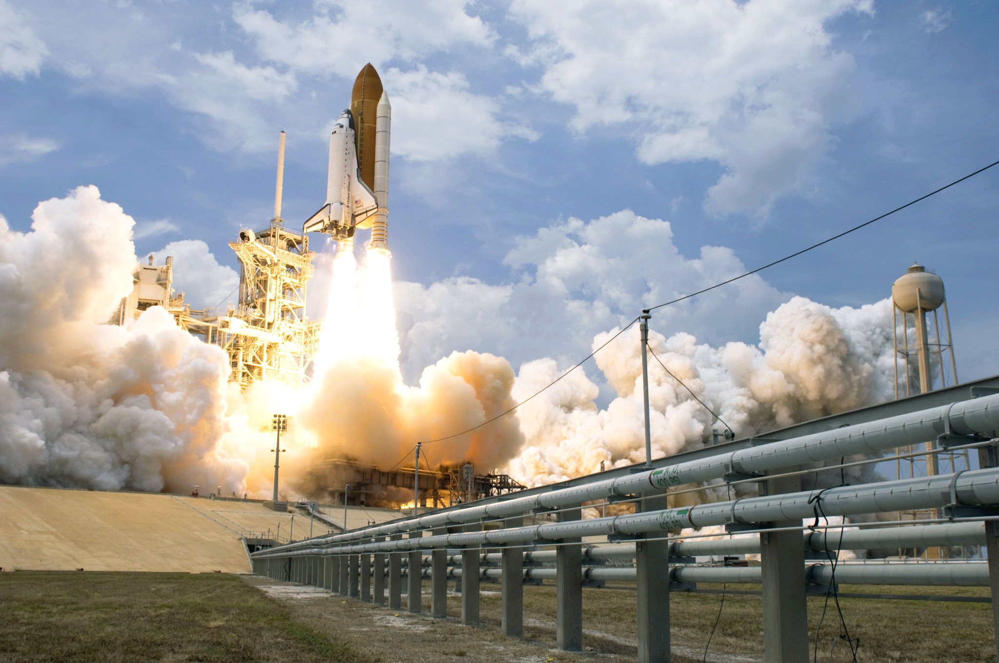 The shuttle at the top of the tower during launch with flames shooting out its main engines and solid rocket motors.