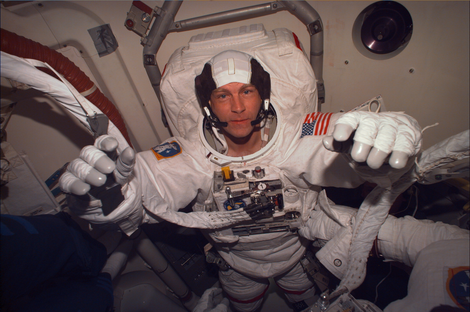 An astronaut starts to unsuit in the crew compartment after a spacewalk.