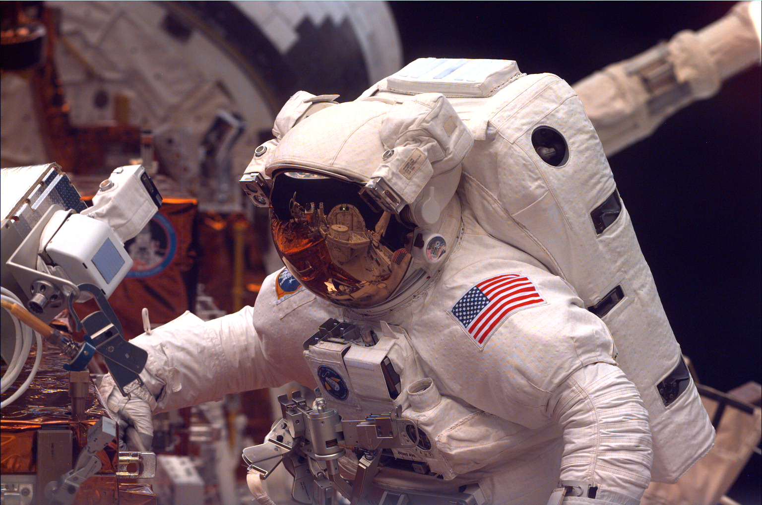 A closeup of an astronaut floating in the cargo bay.