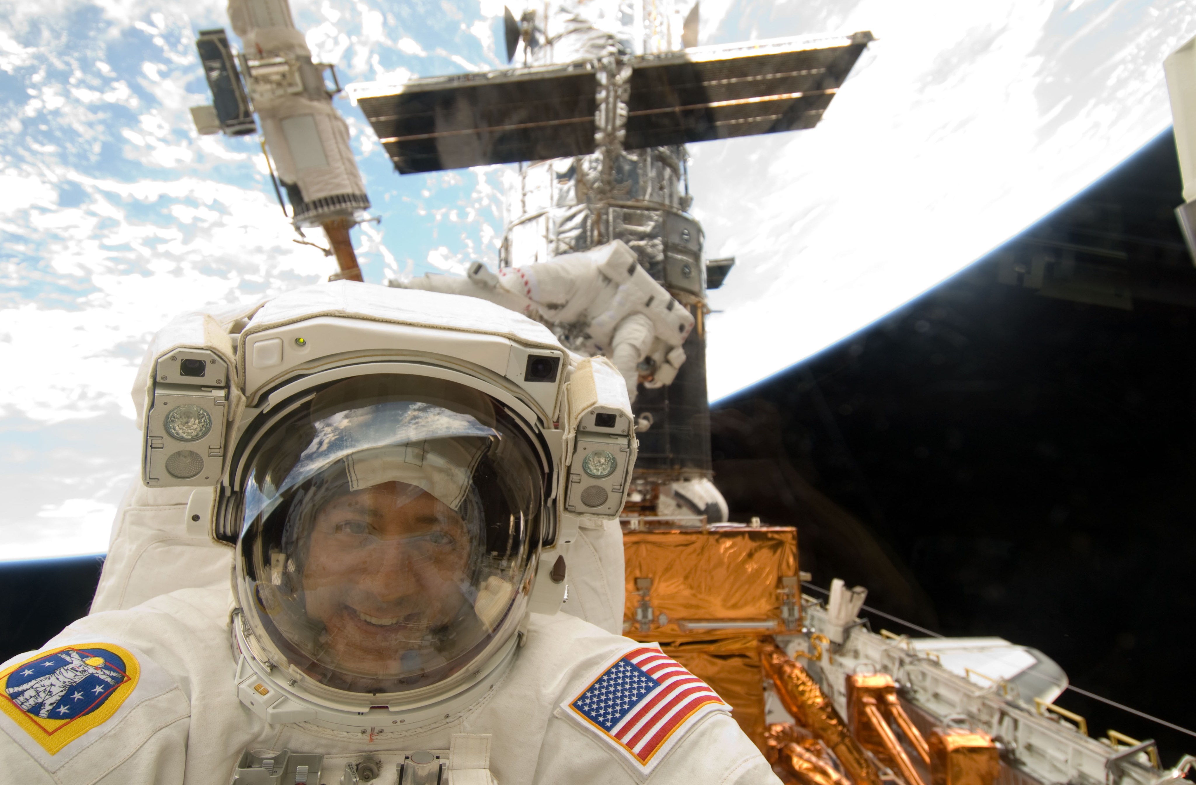 An astronaut poses for a picture through the back windows of the Space Shuttle.