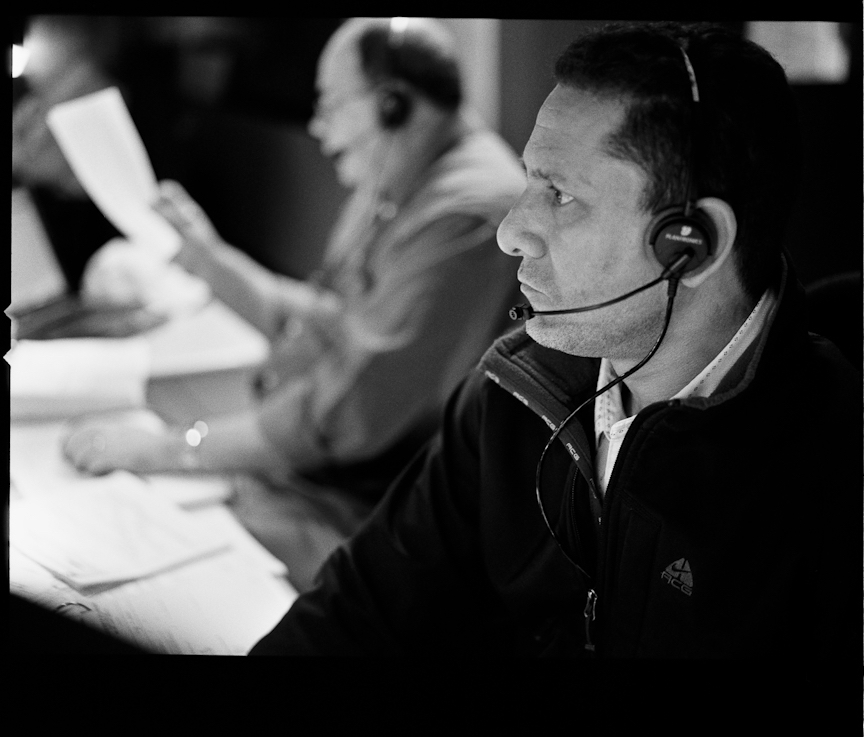 A servicing mission manager with a head set on at his workstation in the control room.