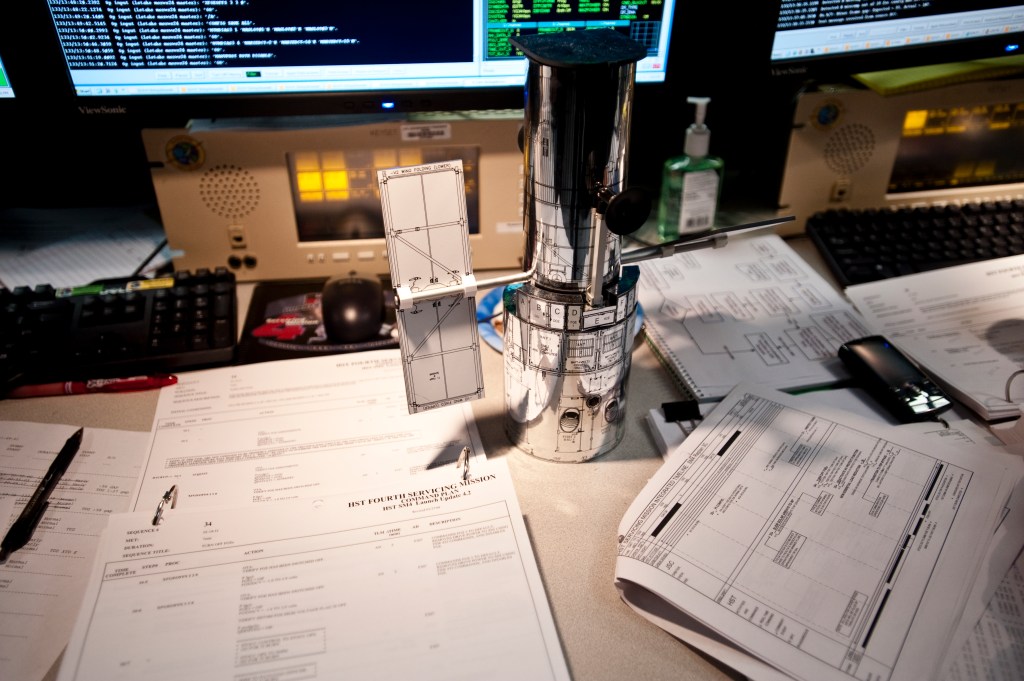 A Hubble model on a table at an engineers workstation in the control room.