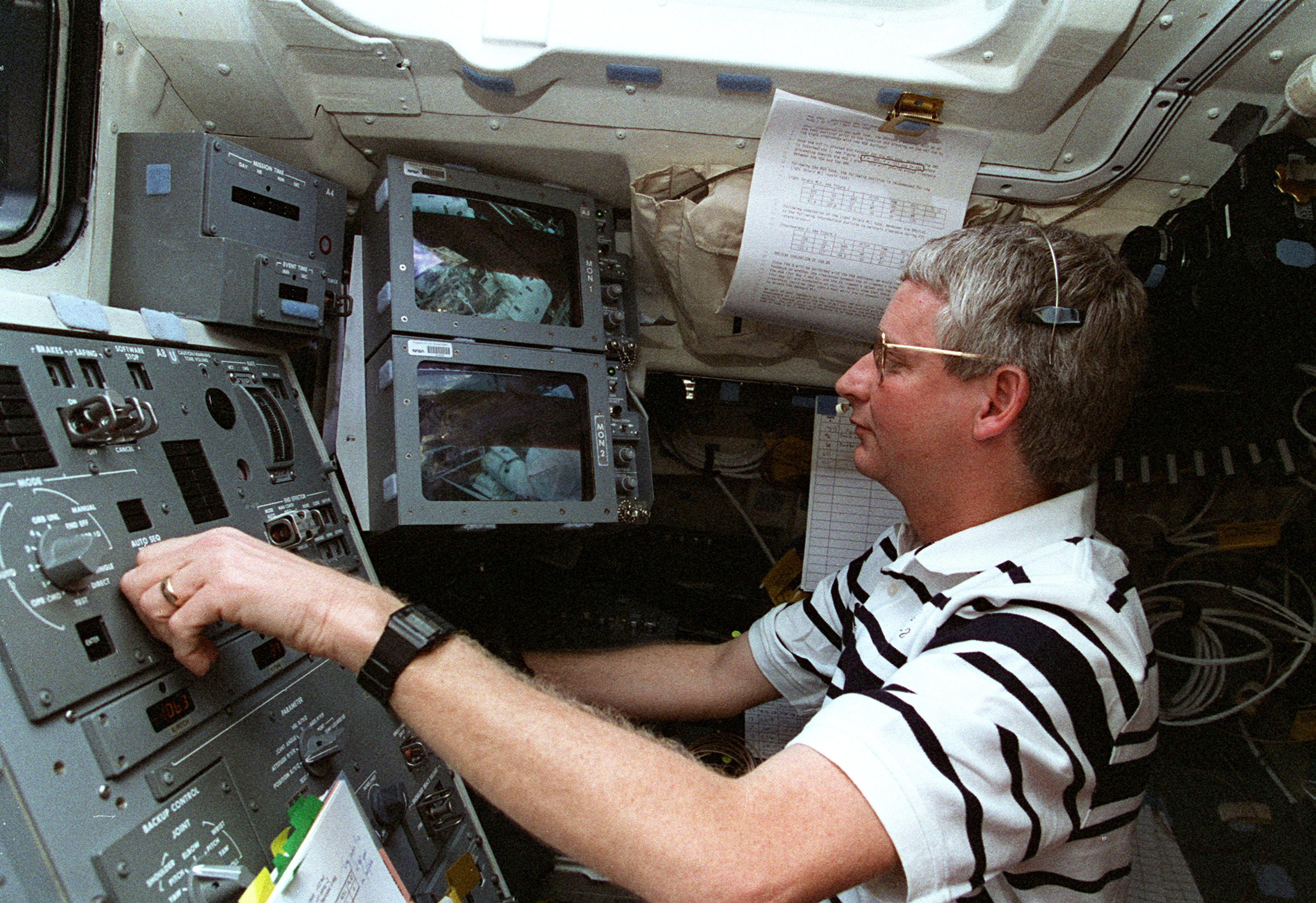 An astronaut works the robotic arm from inside the crew cabin.