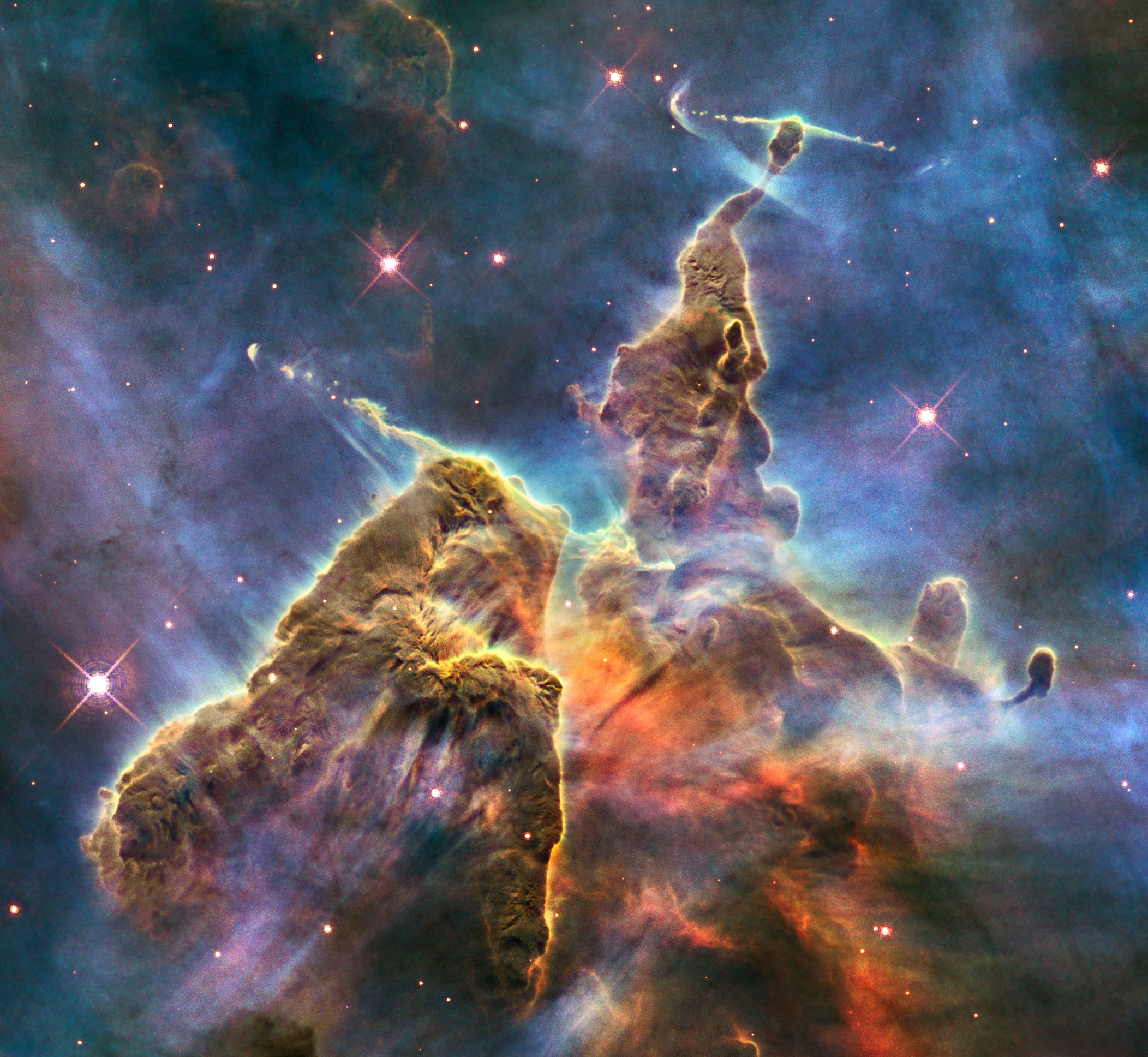 Large orange, yellow, and red clouds of dust and gas. Called Mystic Mountain because they appear as if they're giant mountainous pillars of gas with a blue background.