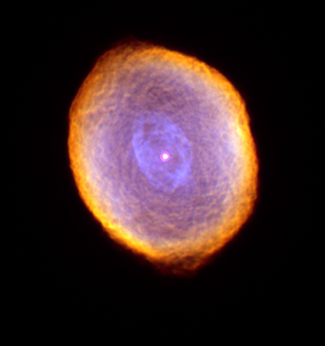 Colorful oval shaped nebula with orange gas on the outside as the color gets more and more purple the more you move to the inside. A bright white/purple star sits at the center.