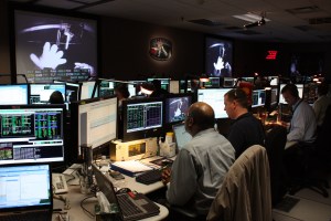 People in the Hubble control center watch the third spacewalk of SM4 on large screen projectors.