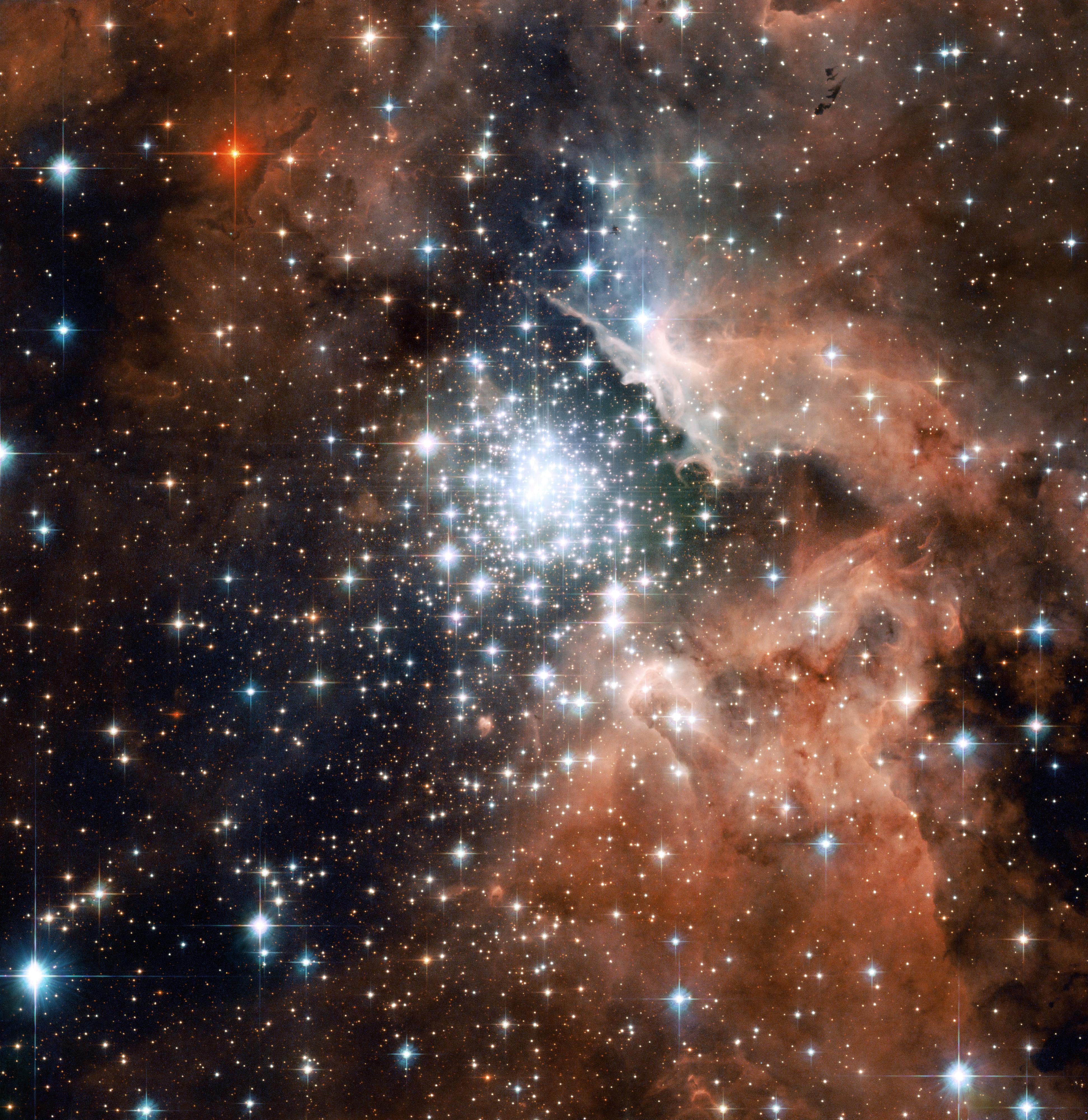Large cluster of stars in the center of the image, surrounded by red dust and gas.