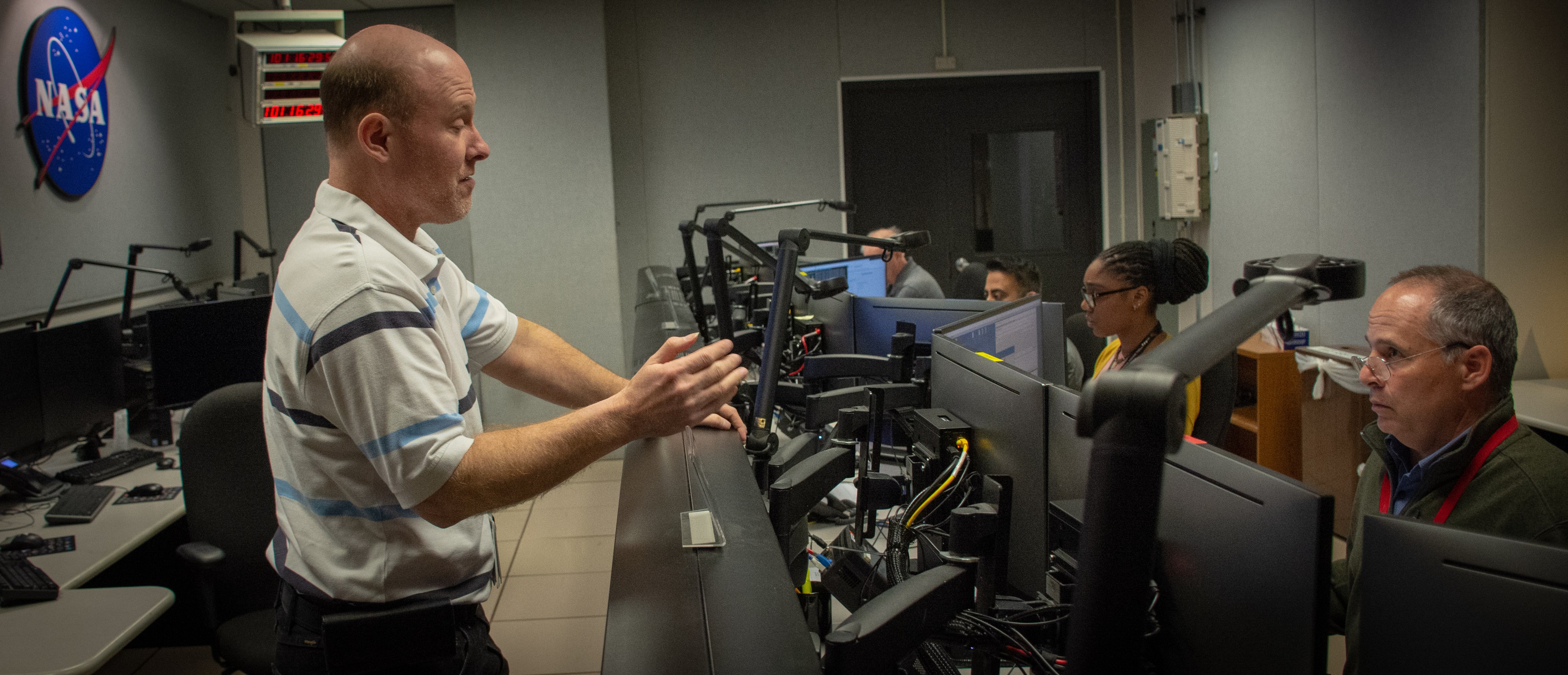 An engineer discusses Hubble spacecraft communications with flight controllers in the Hubble control room.