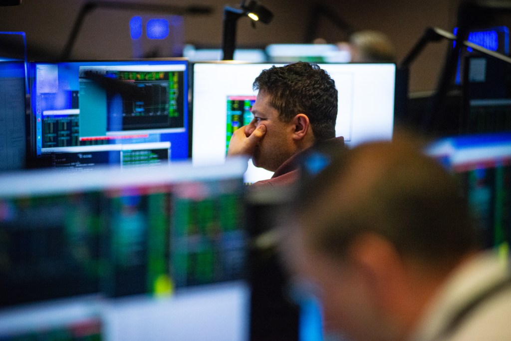 A man sits pensive looking at monitors in a Hubble operations room.