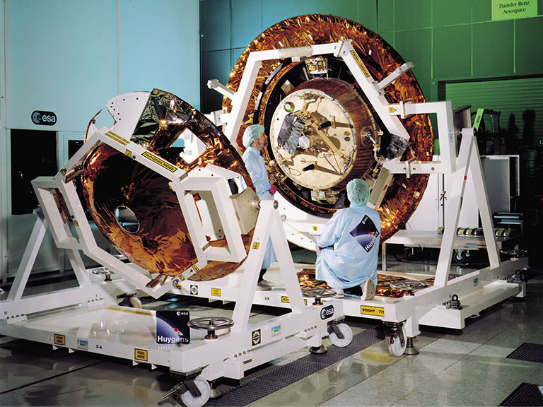 Color image of engineers working on spacecraft.