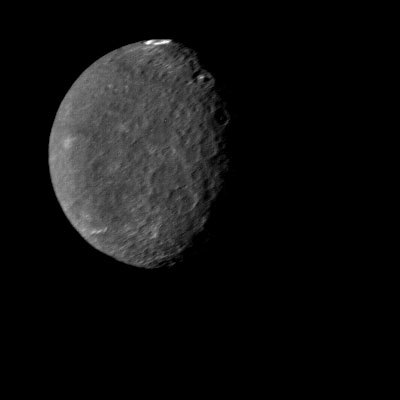 Uranus moon Umbriel has lots of craters and is dark gray in this image.