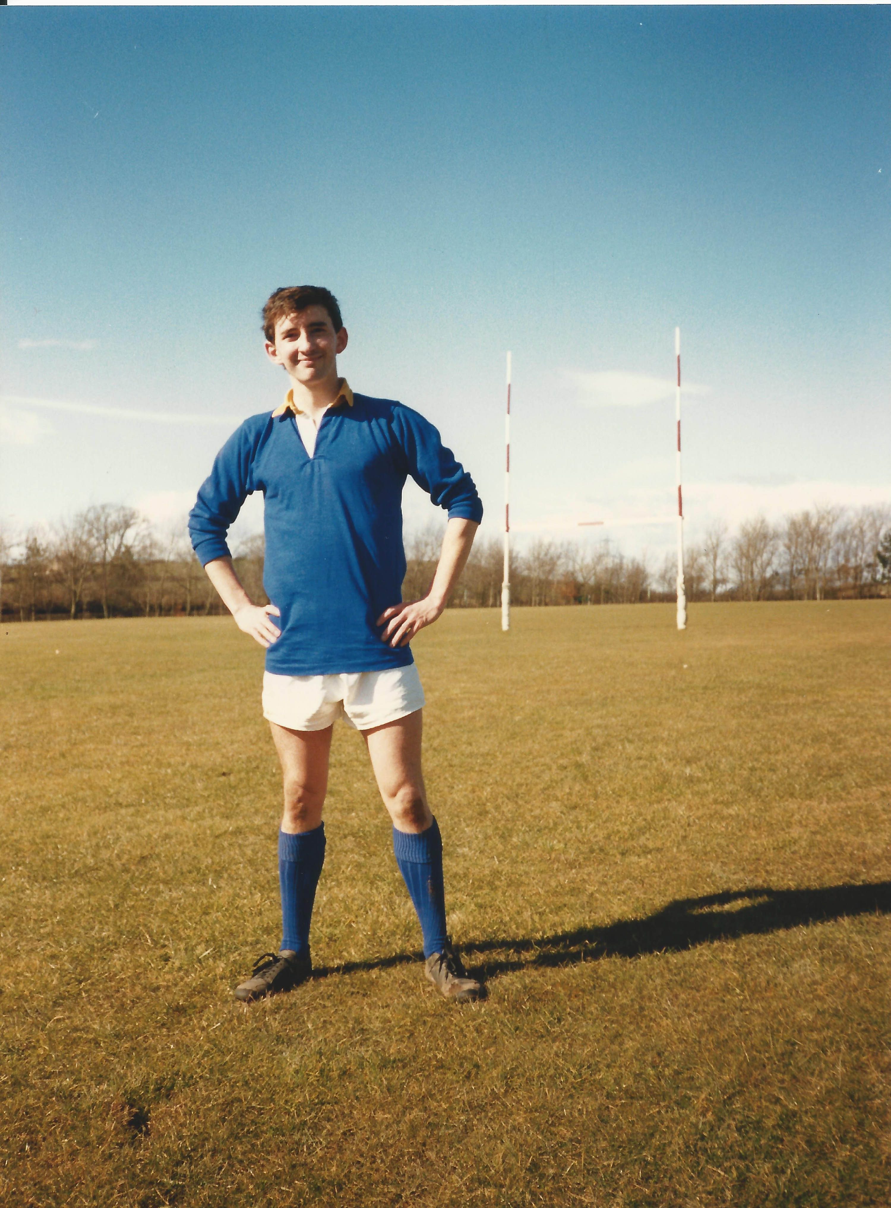 Rugby player posing on the field in a blue jersey