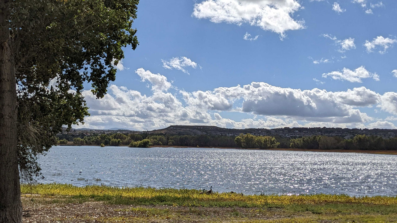 Serene photo of a calm lake under a blue sky