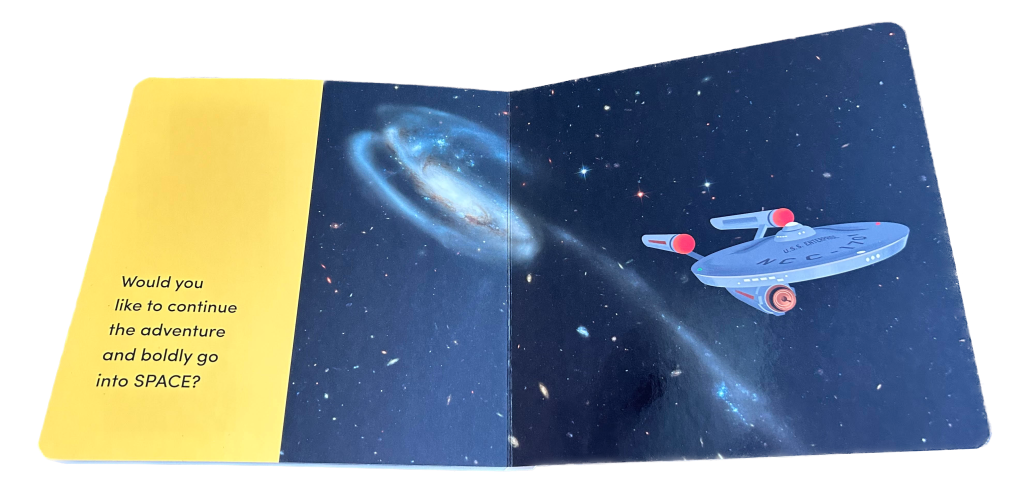 A child's board book shows Hubble's image of the Tadpole Galaxy with a cartoon image of Star Trek's Enterprise flying away from them. On the right the text reads: "Would you like to continue the adventure and boldly go into SPACE?"