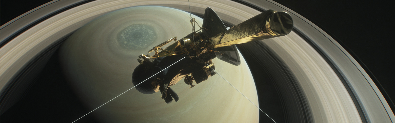 A golden spacecraft is shown above the yellow-brown orb of Saturn and its rings.
