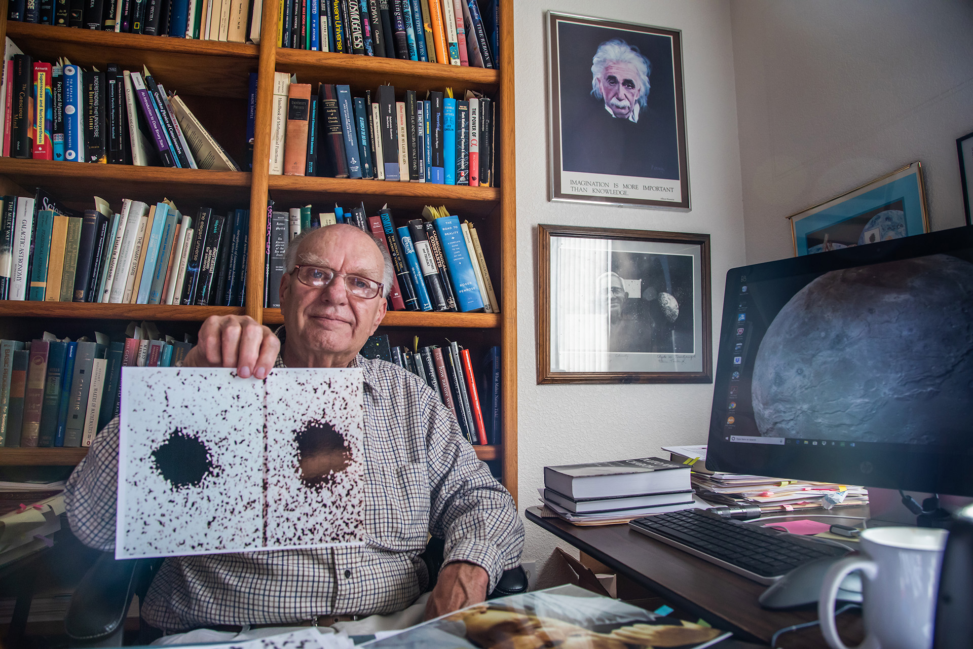 Jim Christy holding his original Charon discovery image in 2018.