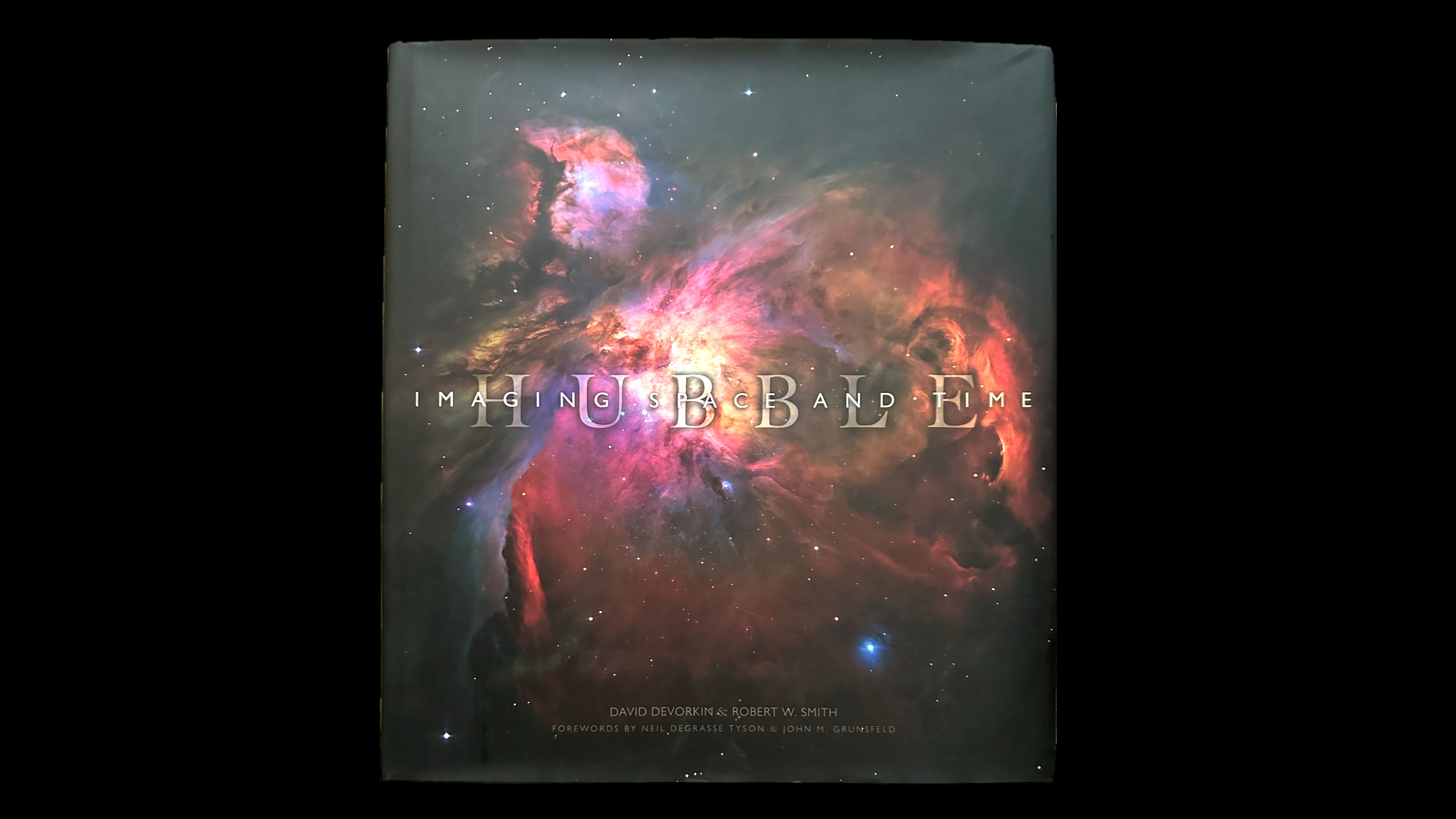 The cover of a national geographic book with Hubble's image of the Orion Nebula on it.