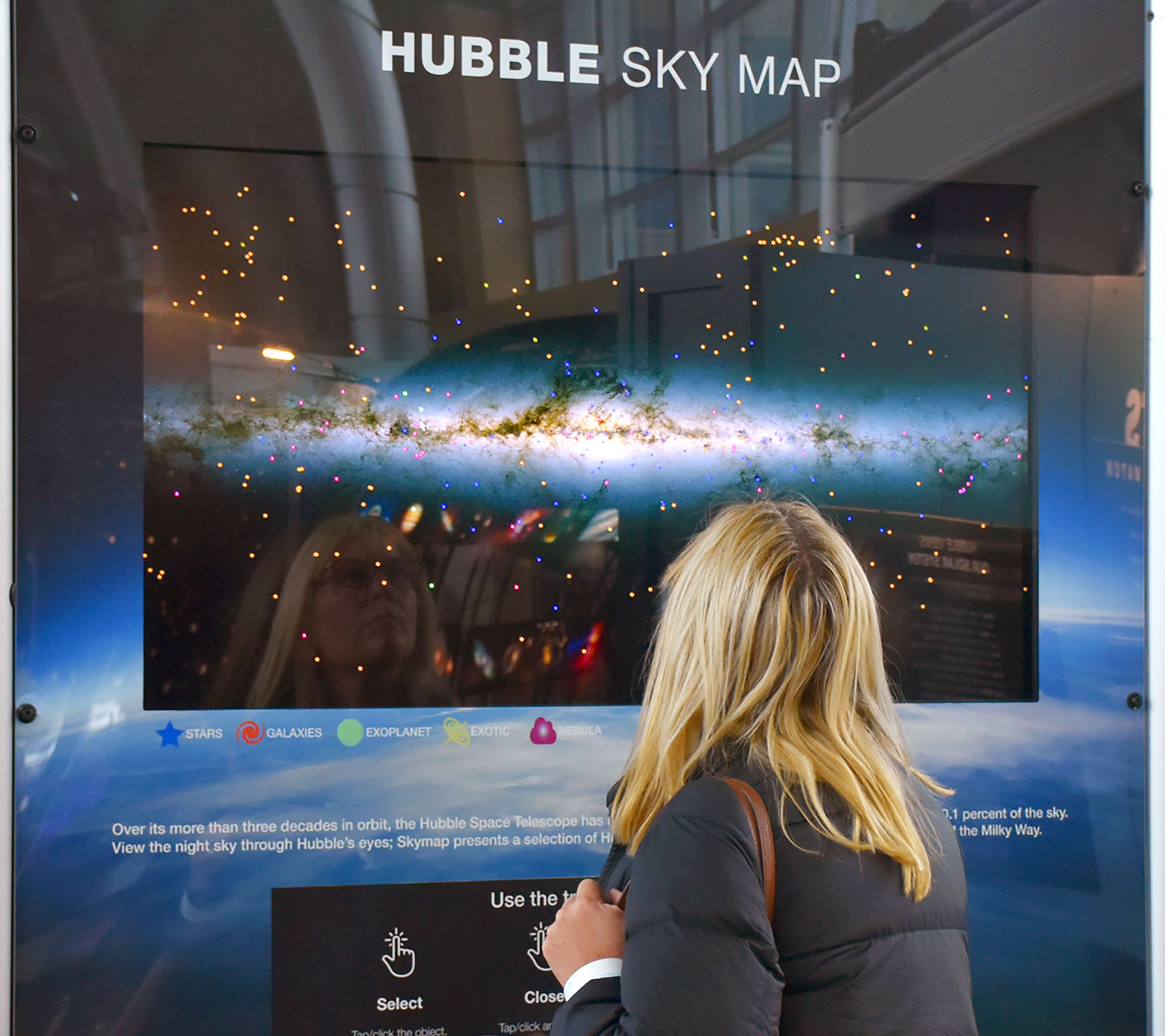 a women looking at a digital display of the Hubble Sky Map on Feb. 11 at INFINITY Science Center