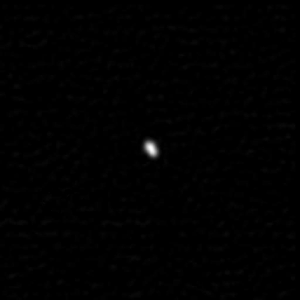 Pluto's smallest moon, Styx, appears like a small. fuzzy white dot in space.