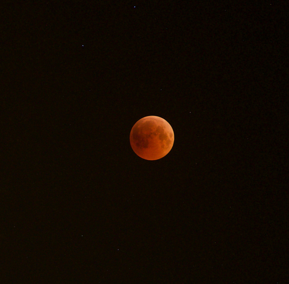 The Moon, colored deep orange as it passes through Earth's shadow.