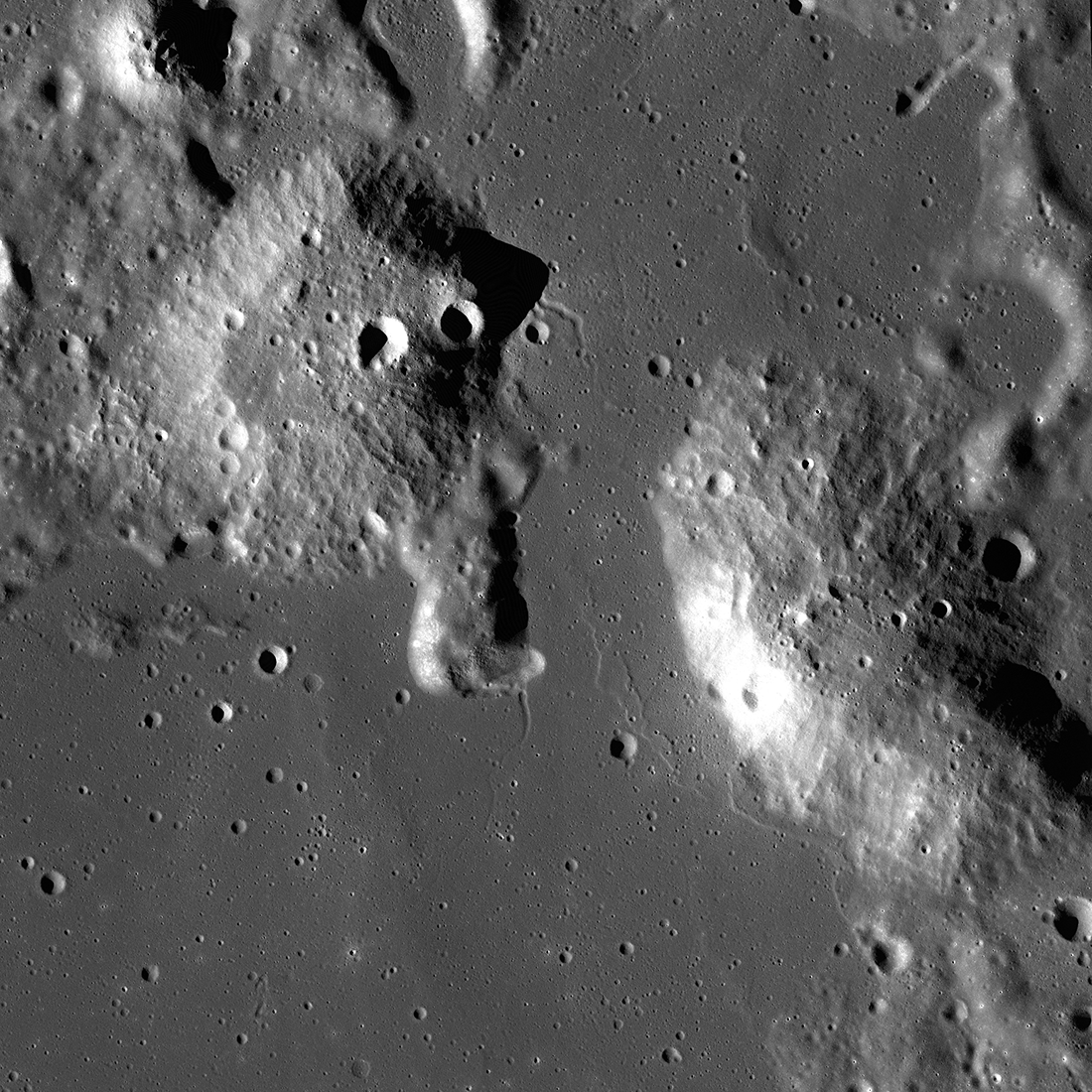 This is an image of the Gruithuisen Domes, taken by the Lunar Reconnaissance Orbiter (LRO). The Domes protrude from the surrounding lunar terrain and are pockmarked with craters.