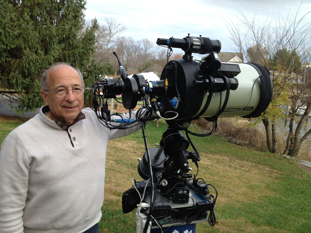 A man posing with his powerful telescope.