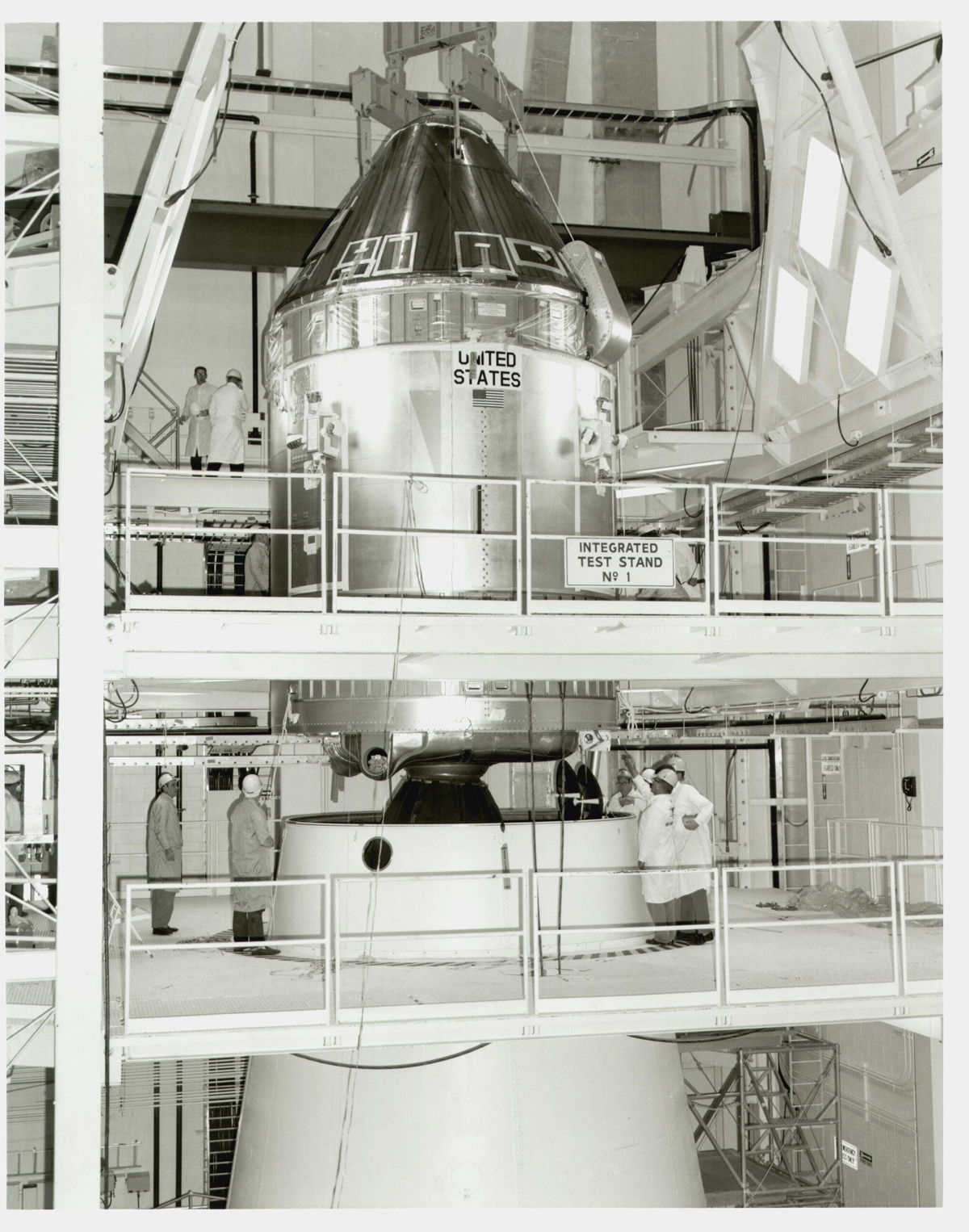 Apollo 11 Command and Service Module, taking up multiple scaffolded floors of an indoor facility, with people working on the upper two floors