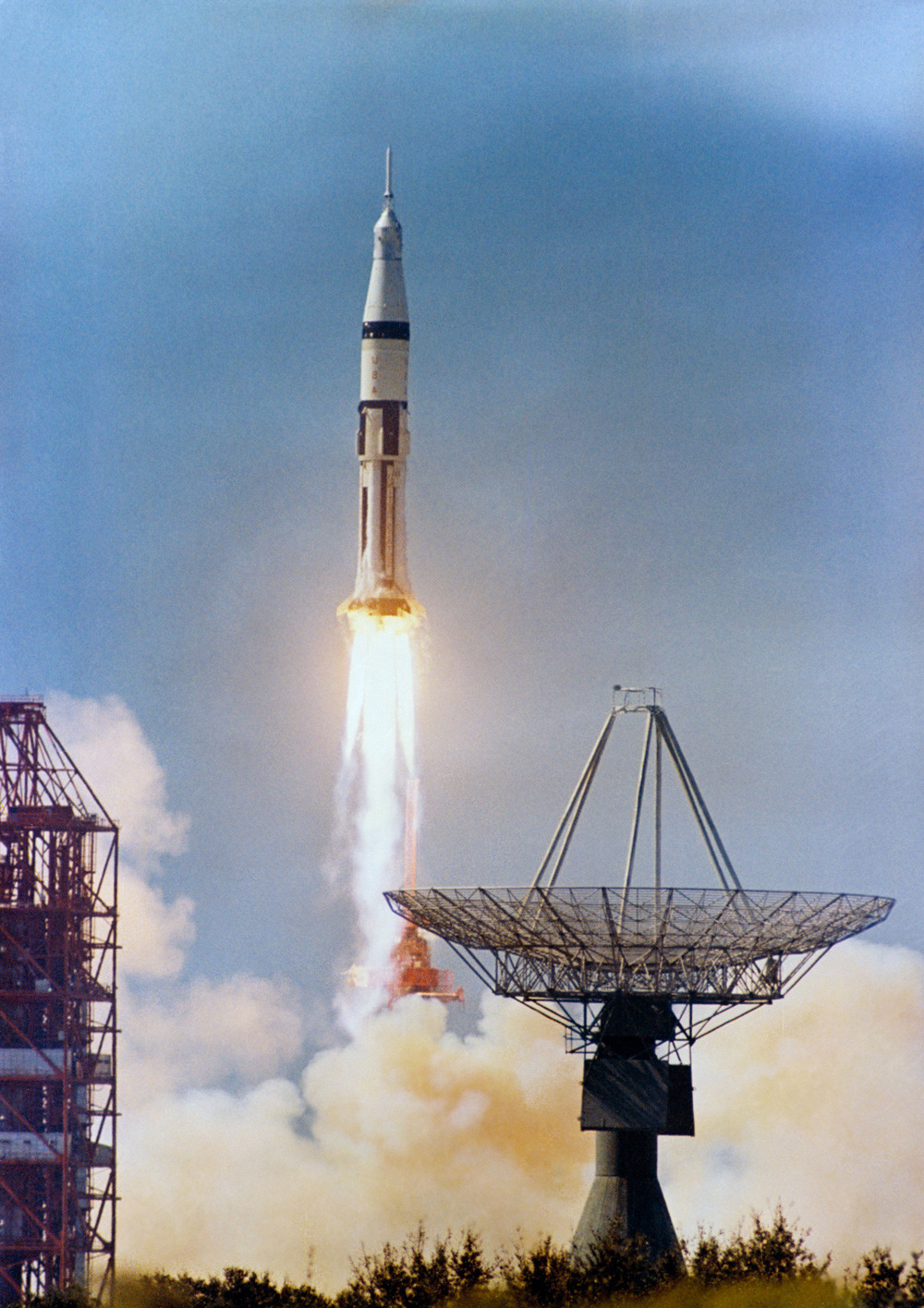 Launch of Apollo 7 space vehicle under a blue sky.