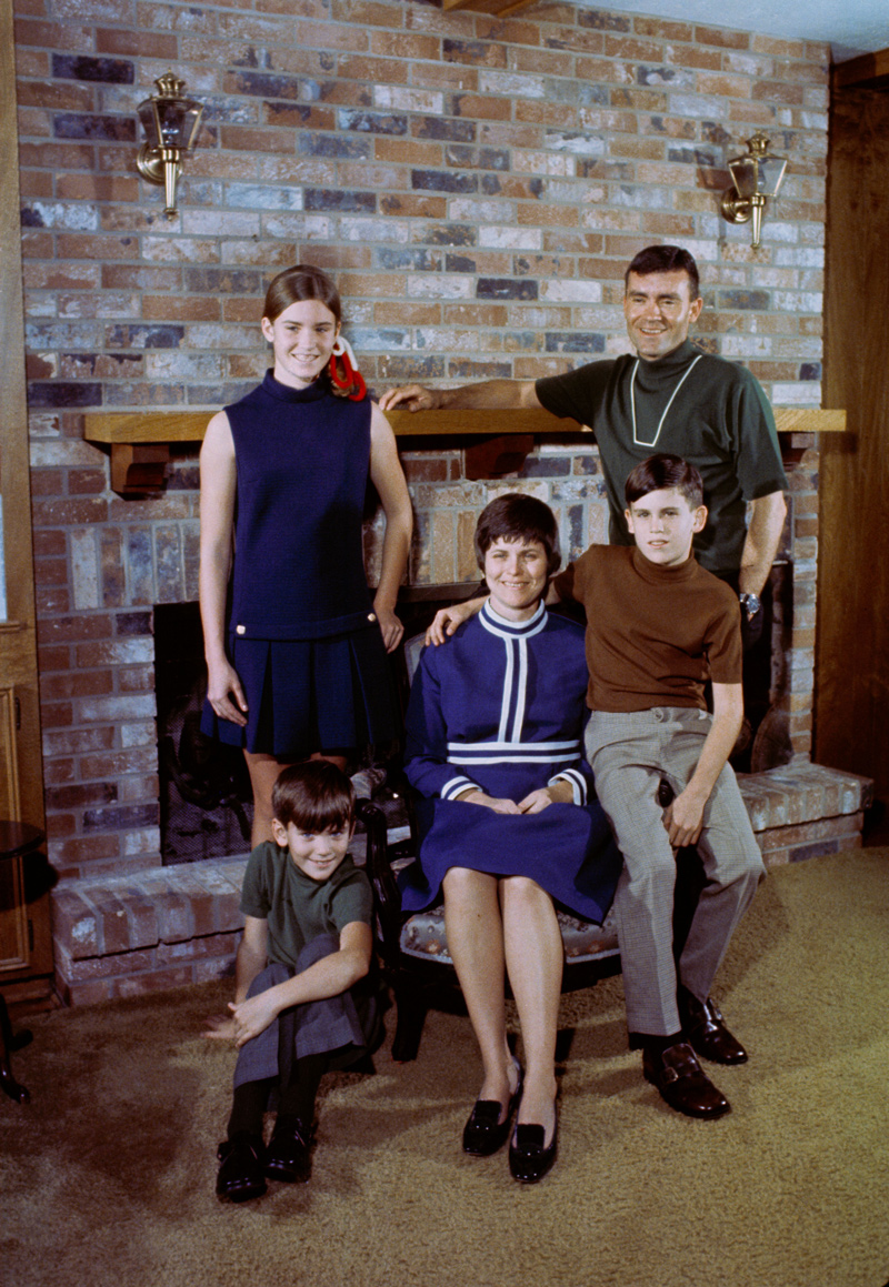 Portrait of astronaut and family in front of a brick fireplace