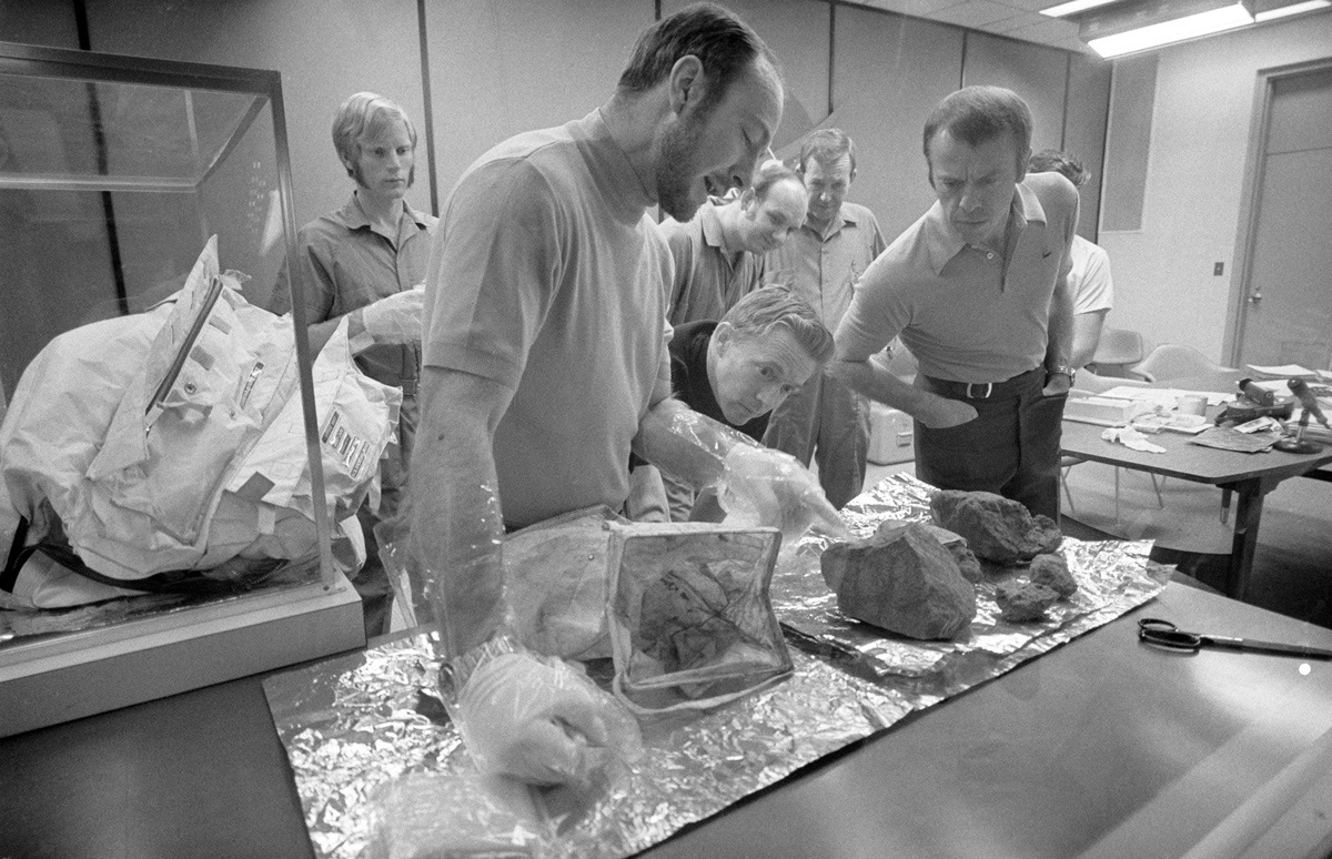 Group of men examining Moon rocks in a lab