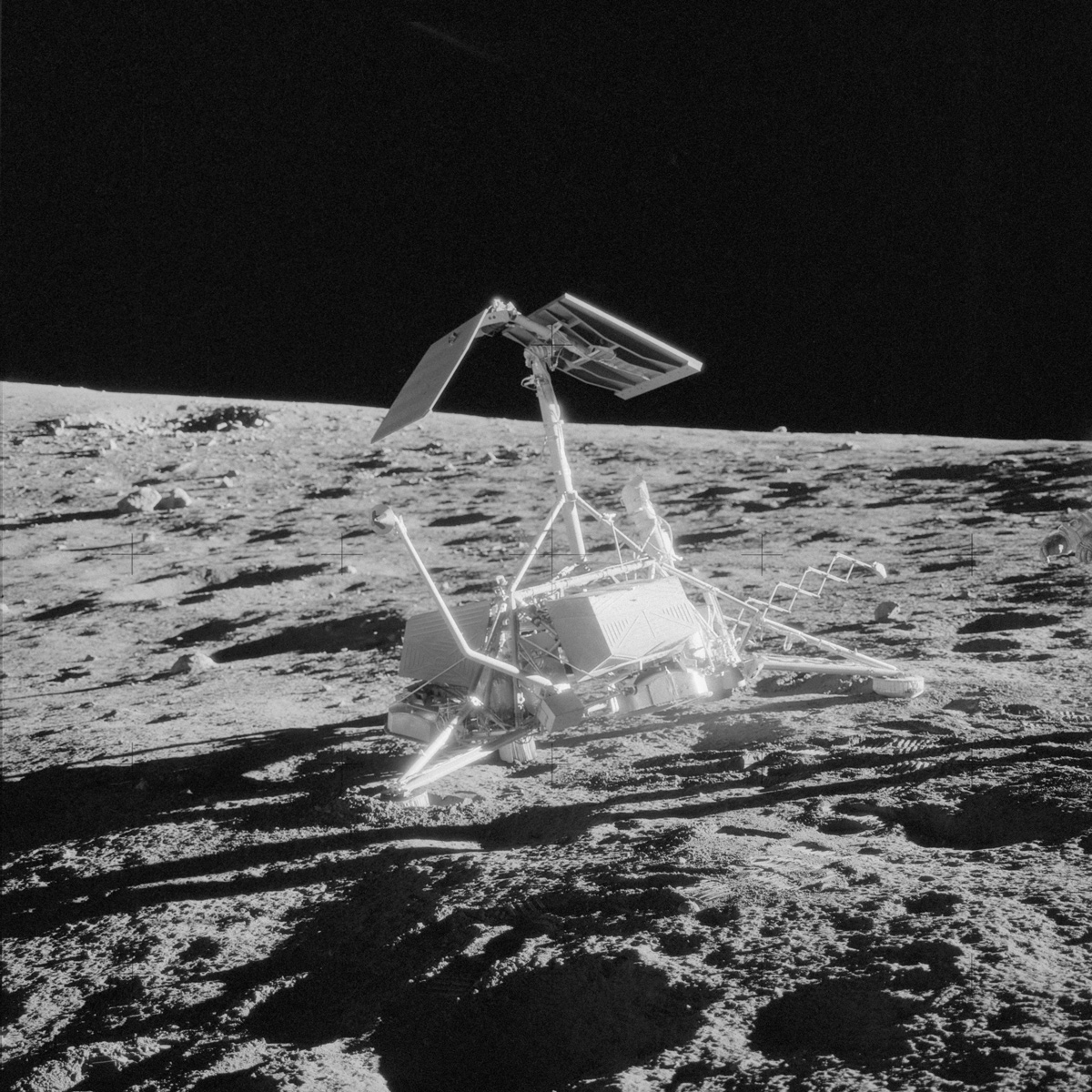 Surveyor 3, a small, white spacecraft, on the Moon's powdery surface