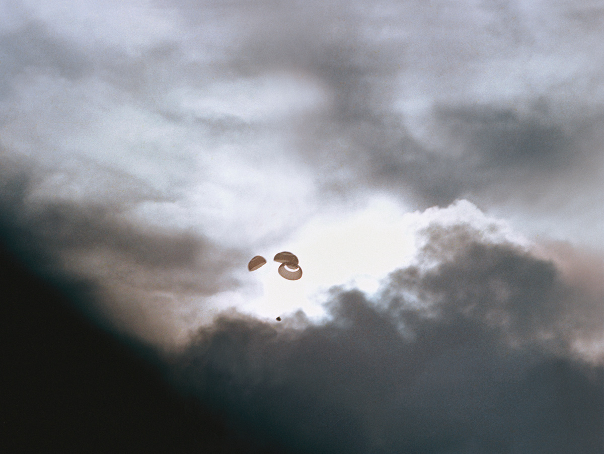 Parachute silhouetted against dramatically-lit clouds