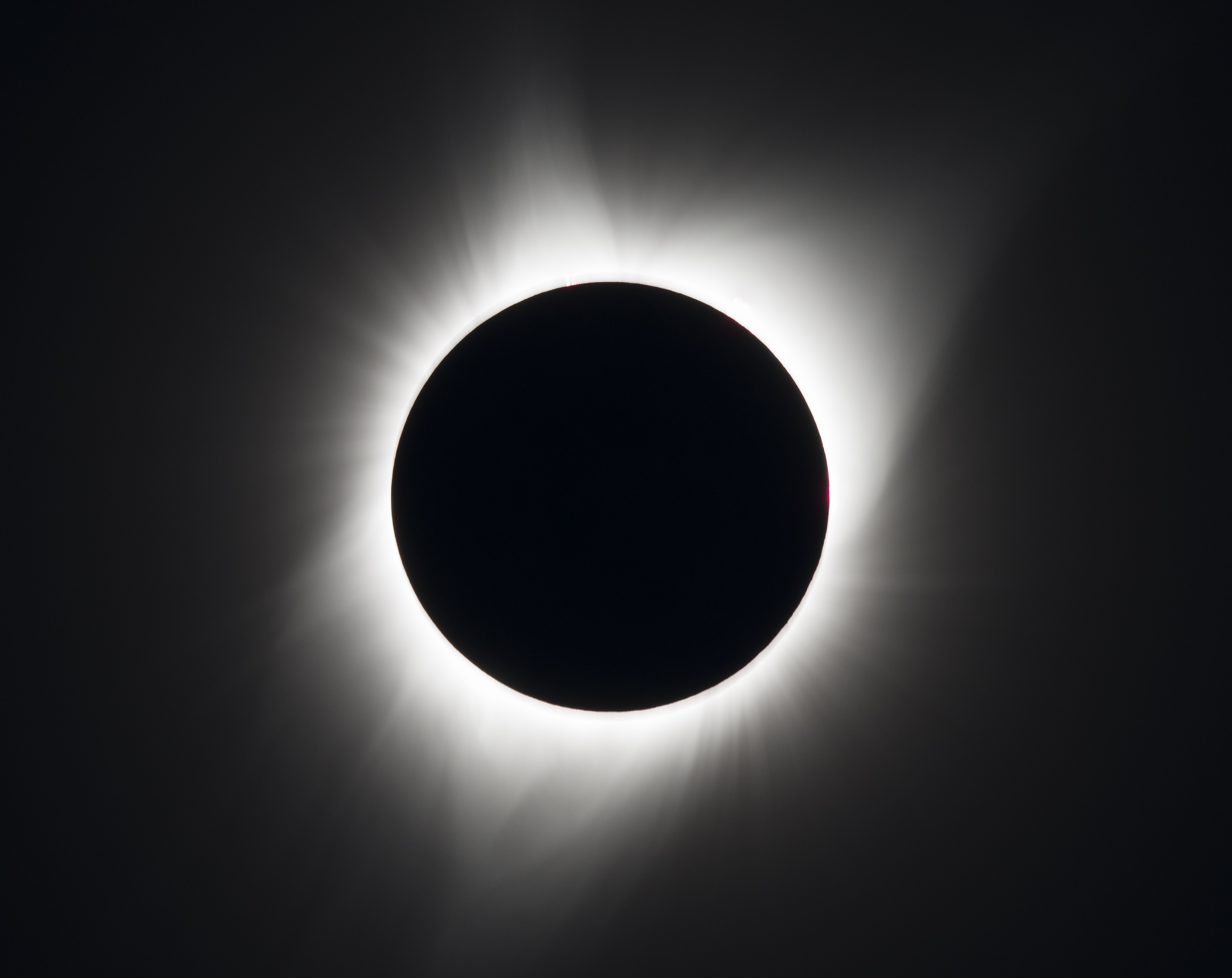 Sun blocked by Moon in total eclipse, with just the solar corona visible as a glow around the silhouetted Moon