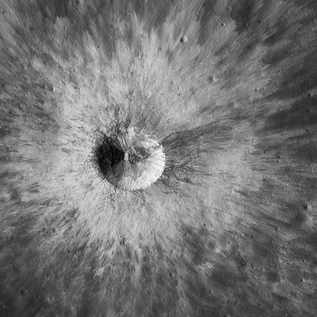 Bright crater seen from directly above, with rays of ejected lunar surface material extending in all directions.